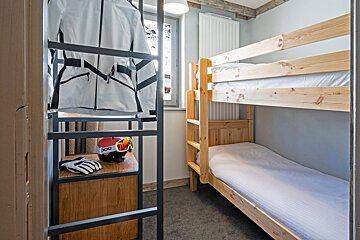 A room with bunk beds and a helmet that says poc on it