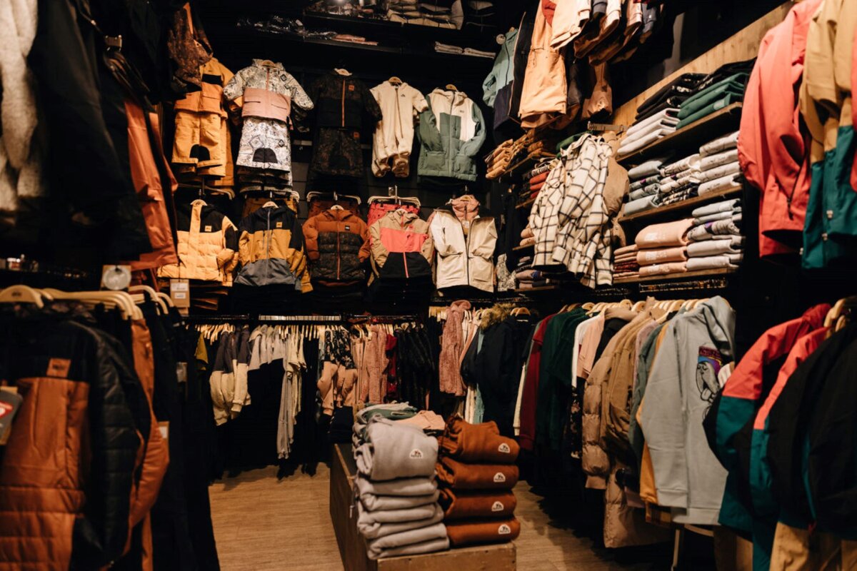 The inside of a clothing store filled with clothes and jackets