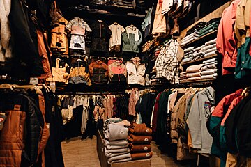 The inside of a clothing store filled with clothes and jackets