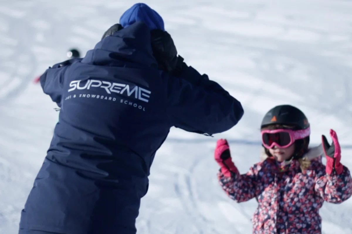 A person wearing a jacket that says supreme on it