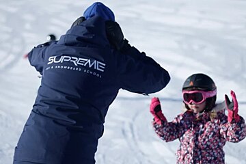 A person wearing a jacket that says supreme on it