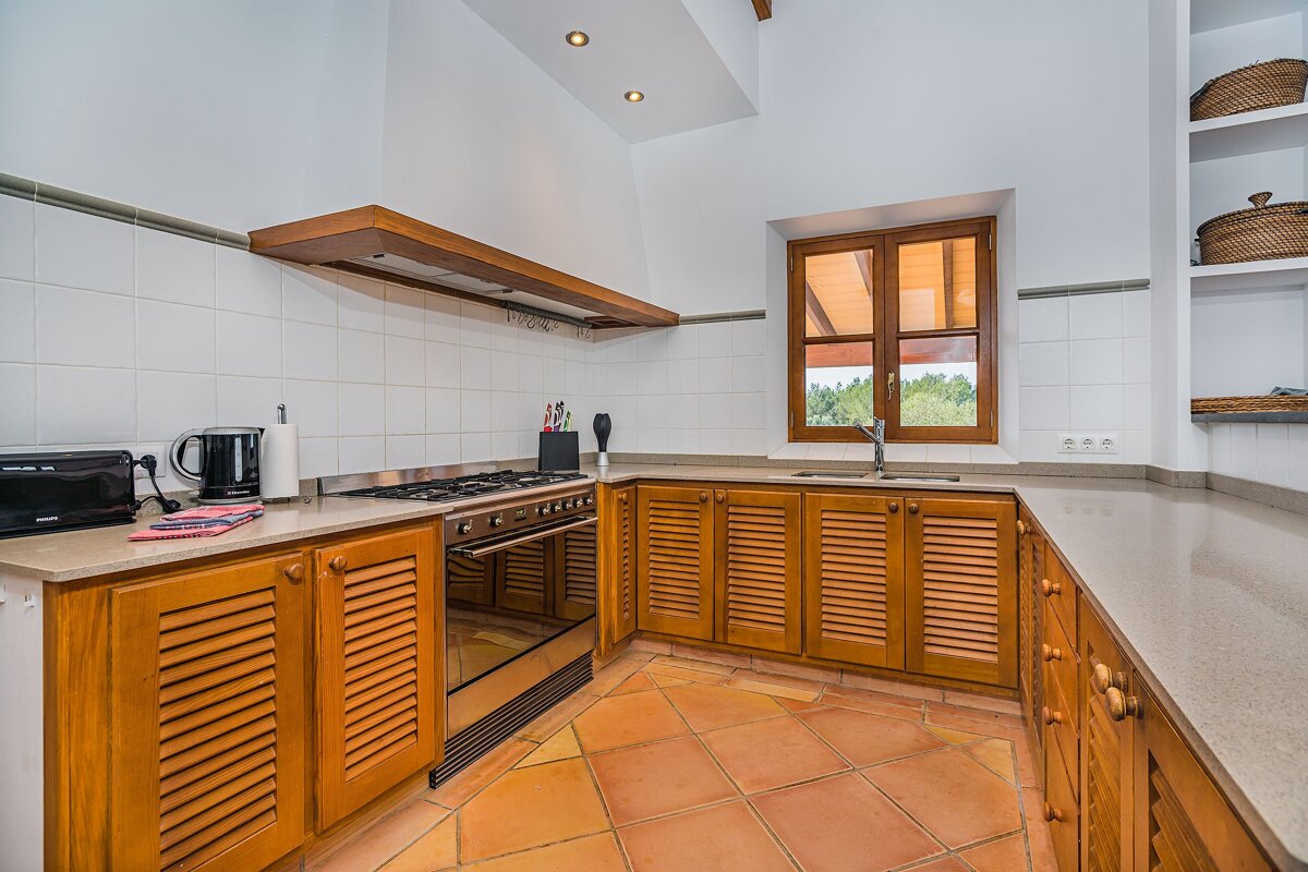A kitchen with wooden cabinets and a black toaster oven