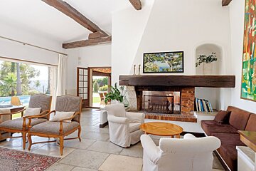 A living room with a fireplace and a painting on the wall
