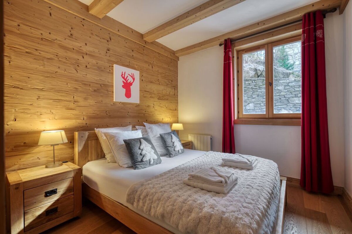 A bedroom with a bed and a picture of a deer on the wall