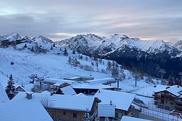 Snowy scene and sunrise behind the mountains in Alpe d'Huez early December 24