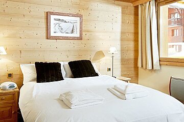 A bedroom with a bed and a picture on the wall