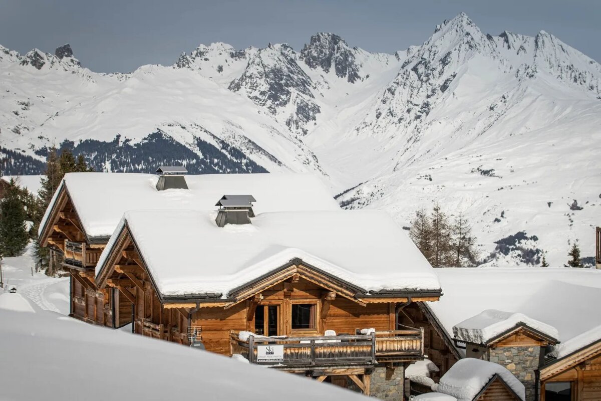 A snowy mountain with a house in the foreground