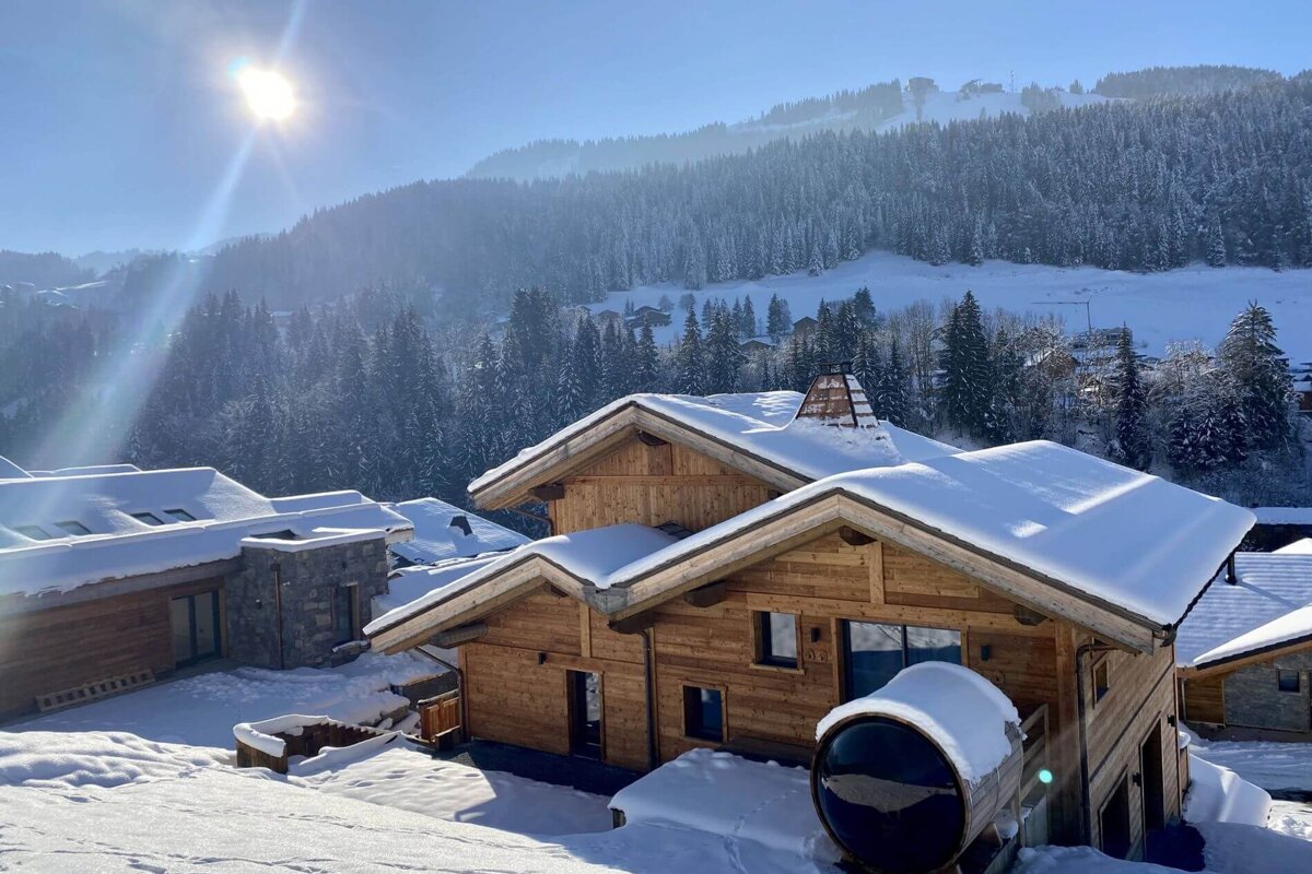 A snowy landscape with a wooden house in the foreground