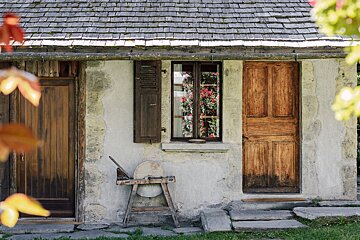 A house with a wooden door and a window with flowers in it