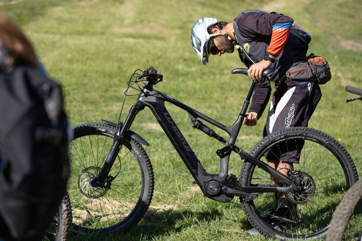 A man wearing a helmet stands next to a bicycle that says trek on it