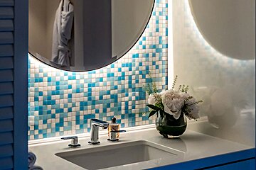 A bathroom with a sink a mirror and a vase of flowers