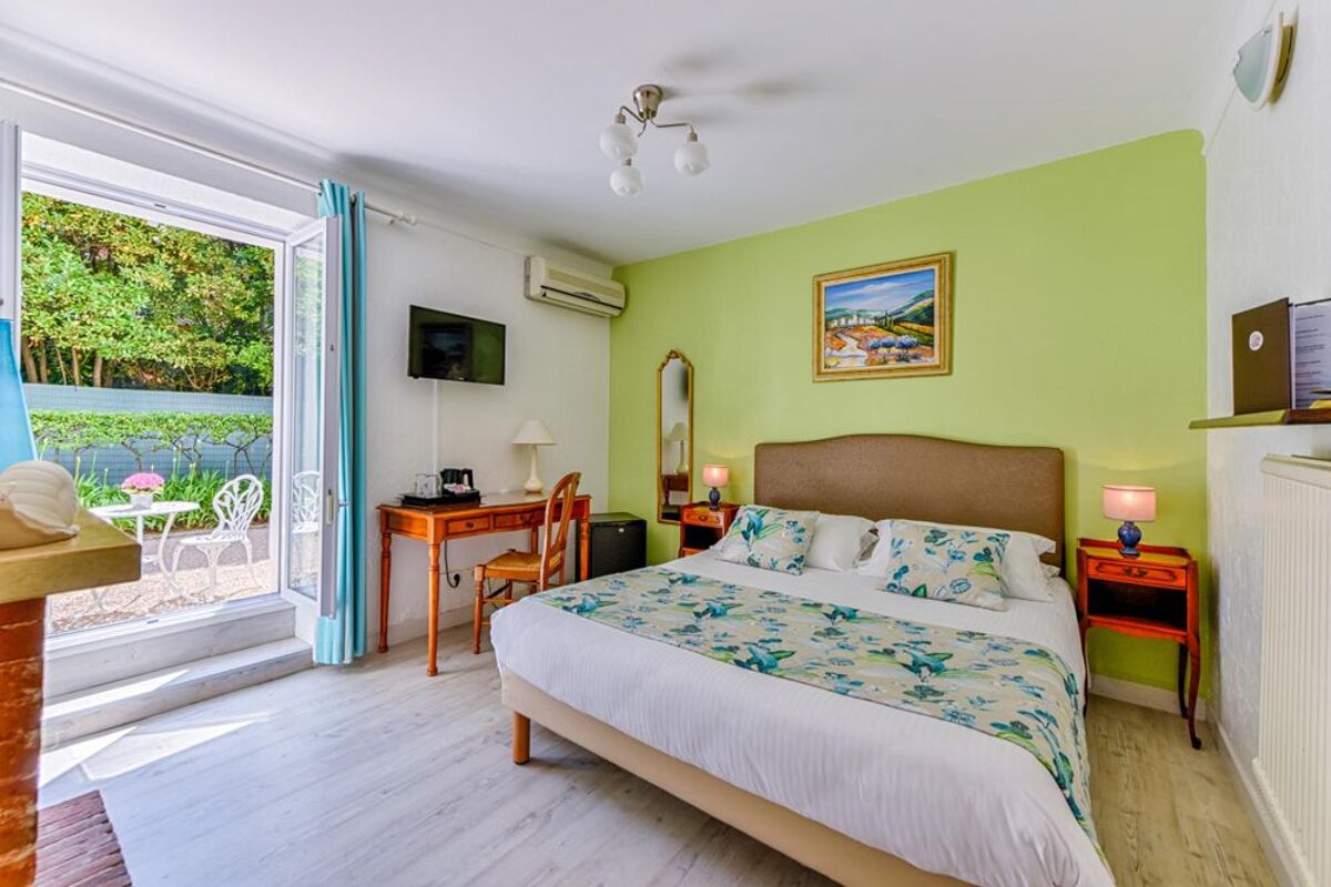 A hotel room with a large bed and a painting on the wall