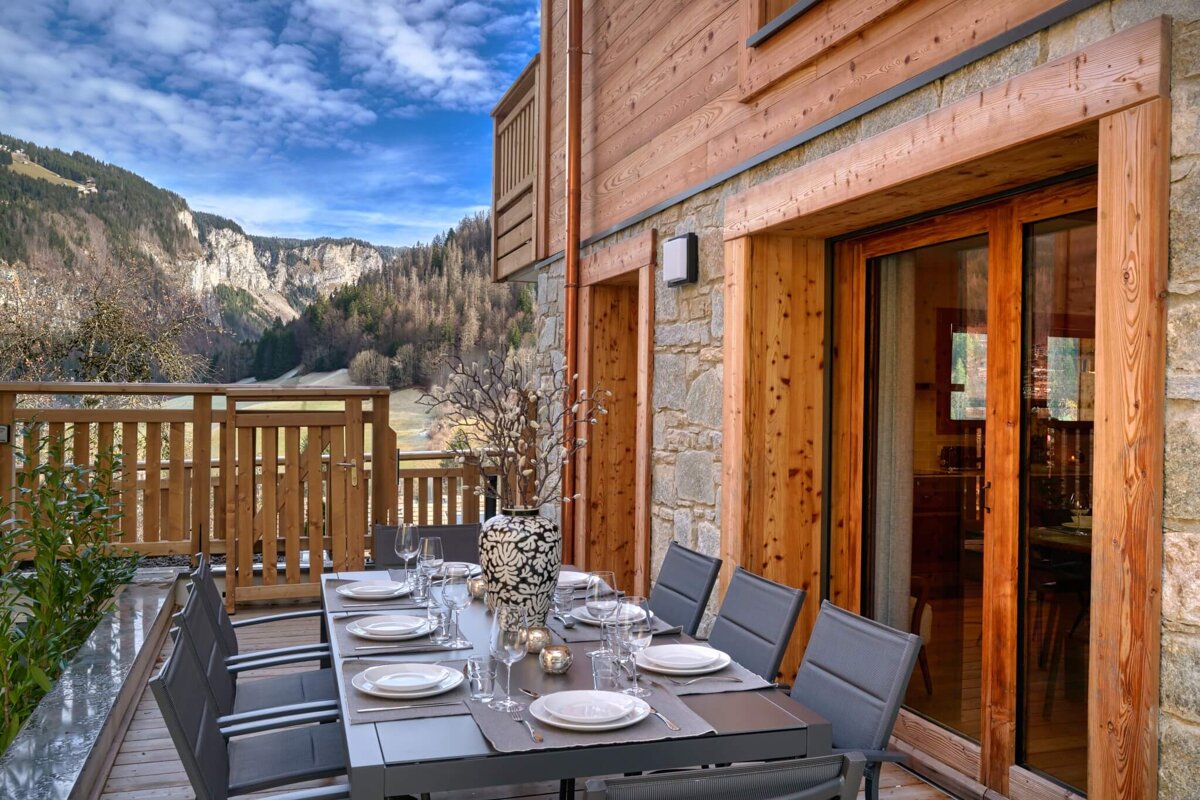 A dining table with a vase of flowers on it