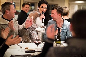 A woman in a white dress is singing into a microphone