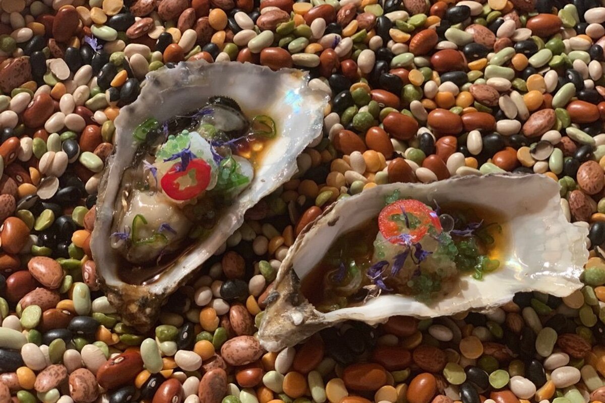 Two oysters are sitting on a pile of beans