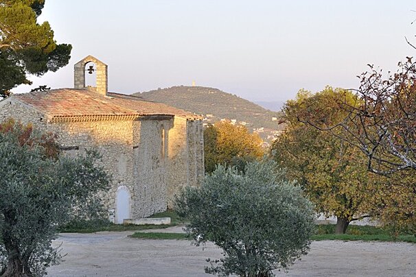 A stone building with a bell on the top of it