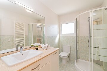 A bathroom with a toilet a sink and a shower