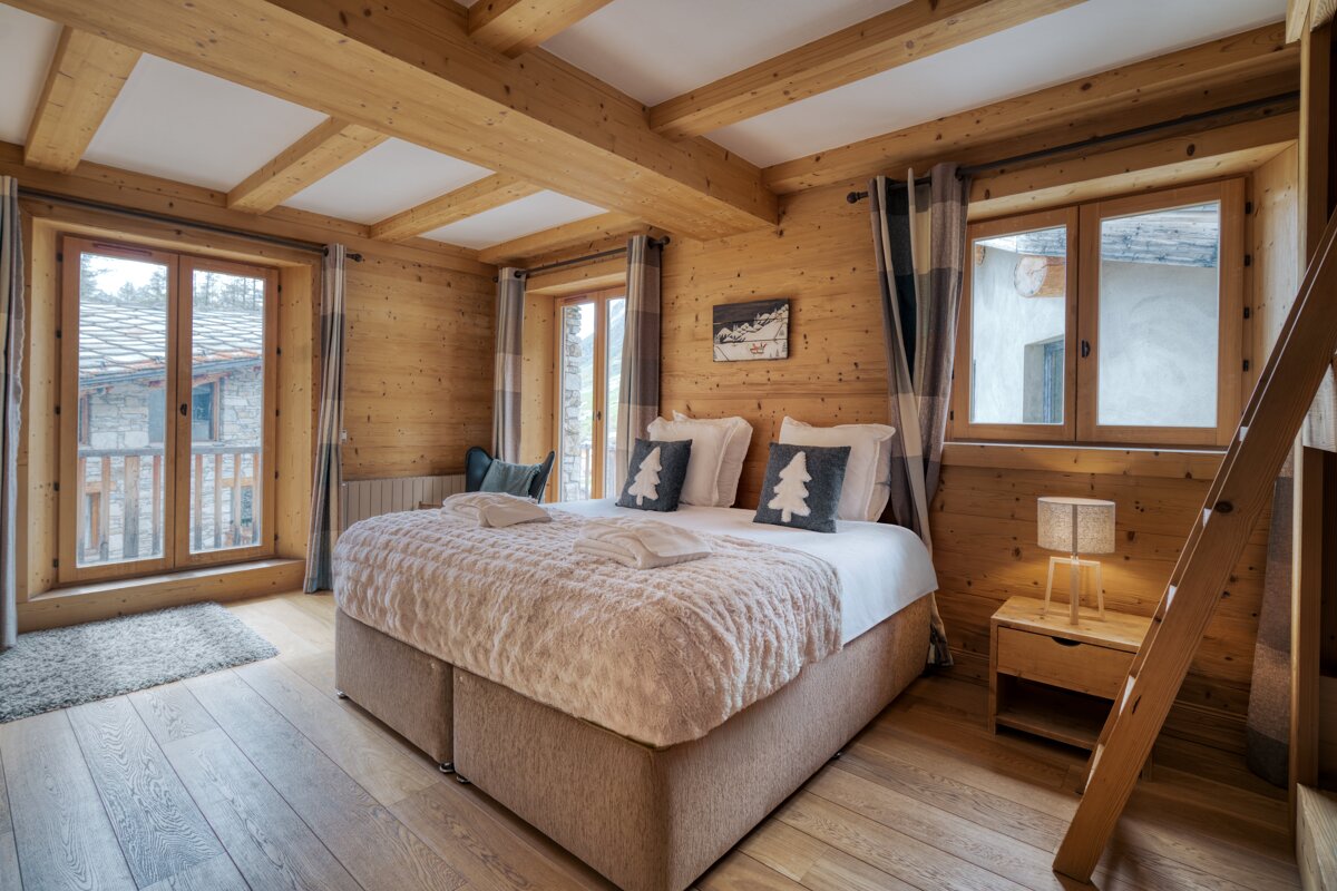 A bedroom with a large bed and a ladder