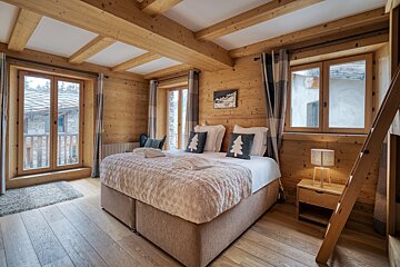 A bedroom with a large bed and a ladder