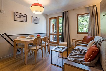 A living room with a dining table and chairs