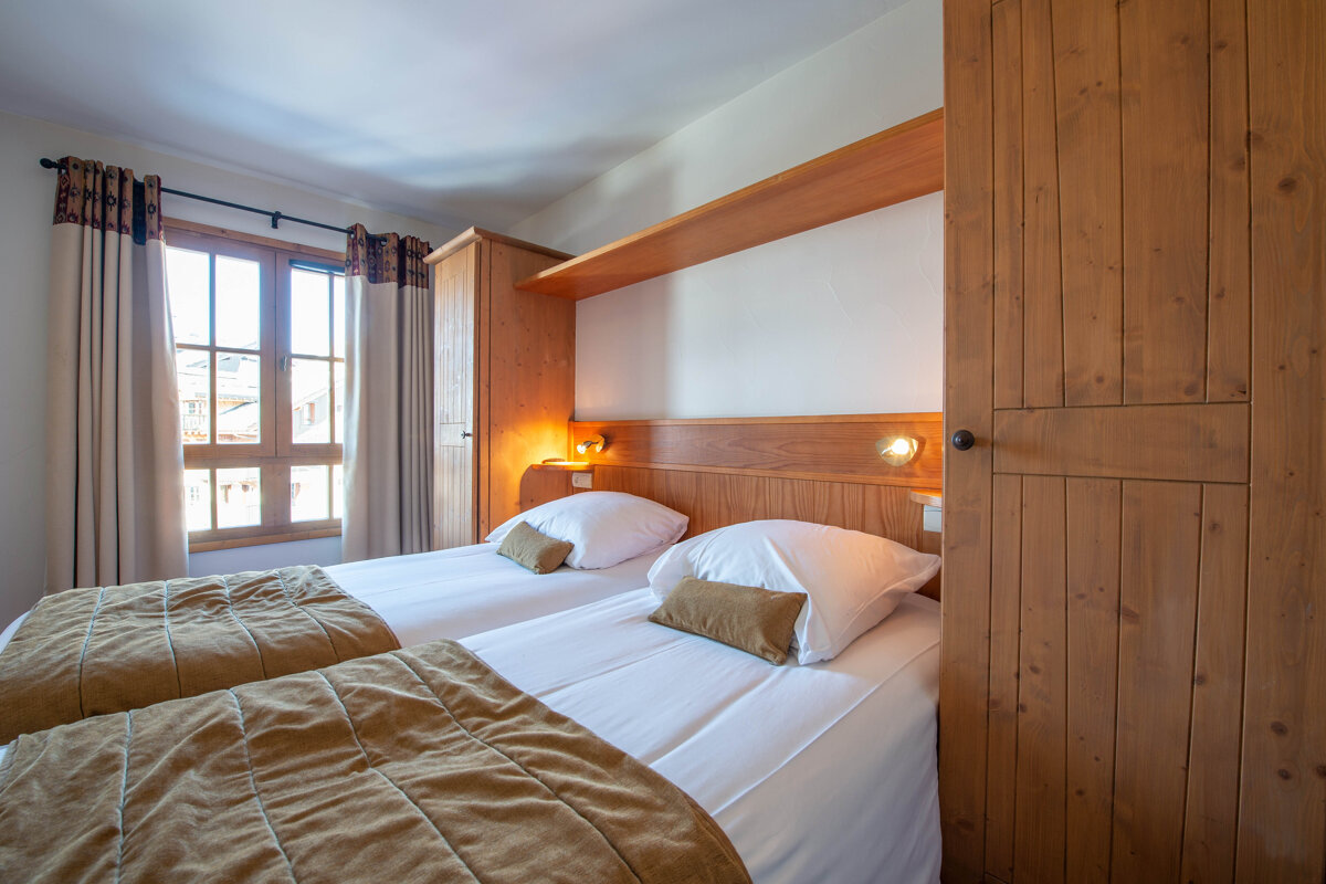 A bedroom with two beds and a window