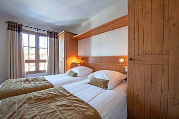 A bedroom with two beds and a window