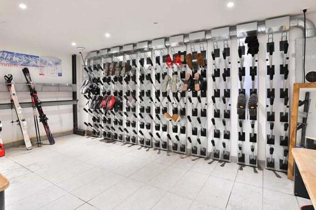 Several pairs of atomic skis are lined up against a wall