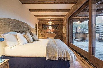 A bedroom with a large bed and sliding glass doors