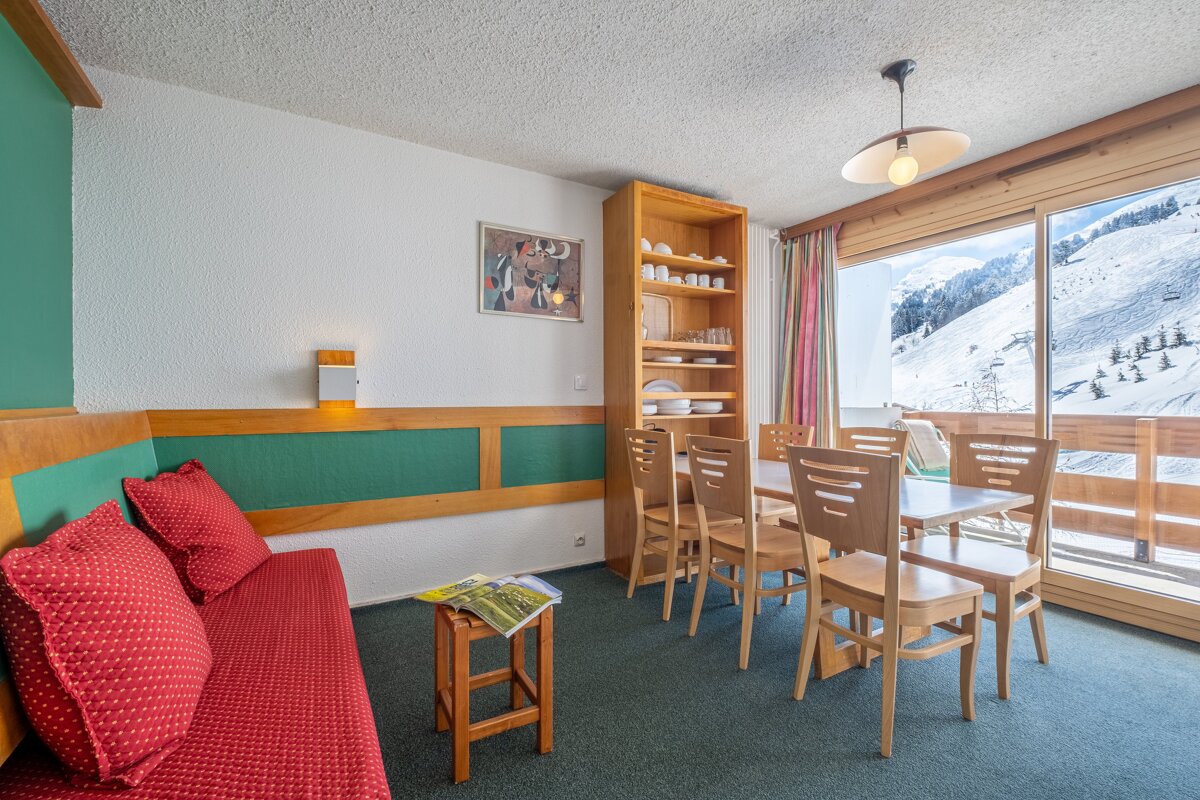 A living room with a table and chairs and a picture on the wall