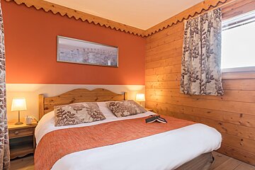 A bedroom with a bed and a picture on the wall