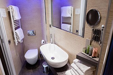 A bathroom with a toilet a sink and a mirror