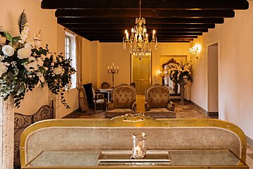 A room with two chairs and a chandelier hanging from the ceiling