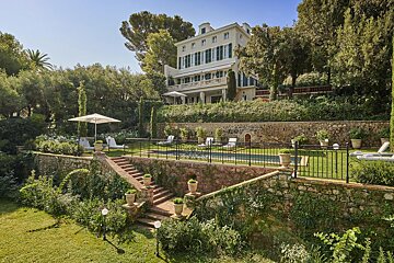 A large white house with a swimming pool in front of it