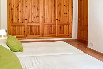 A bedroom with wooden doors and a bed with green pillows
