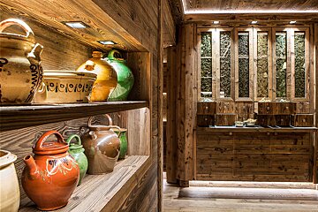 A row of ceramic pots on a wooden shelf one of which has the number 19 on it