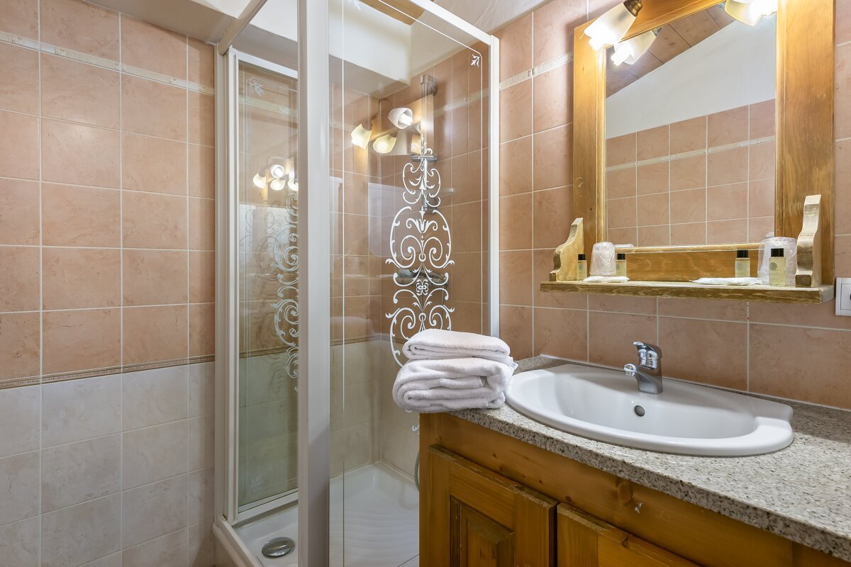 A bathroom with a sink a mirror and a shower