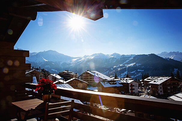 A balcony with a view of a snowy mountain range