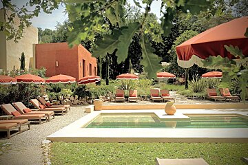 A swimming pool surrounded by chairs and umbrellas