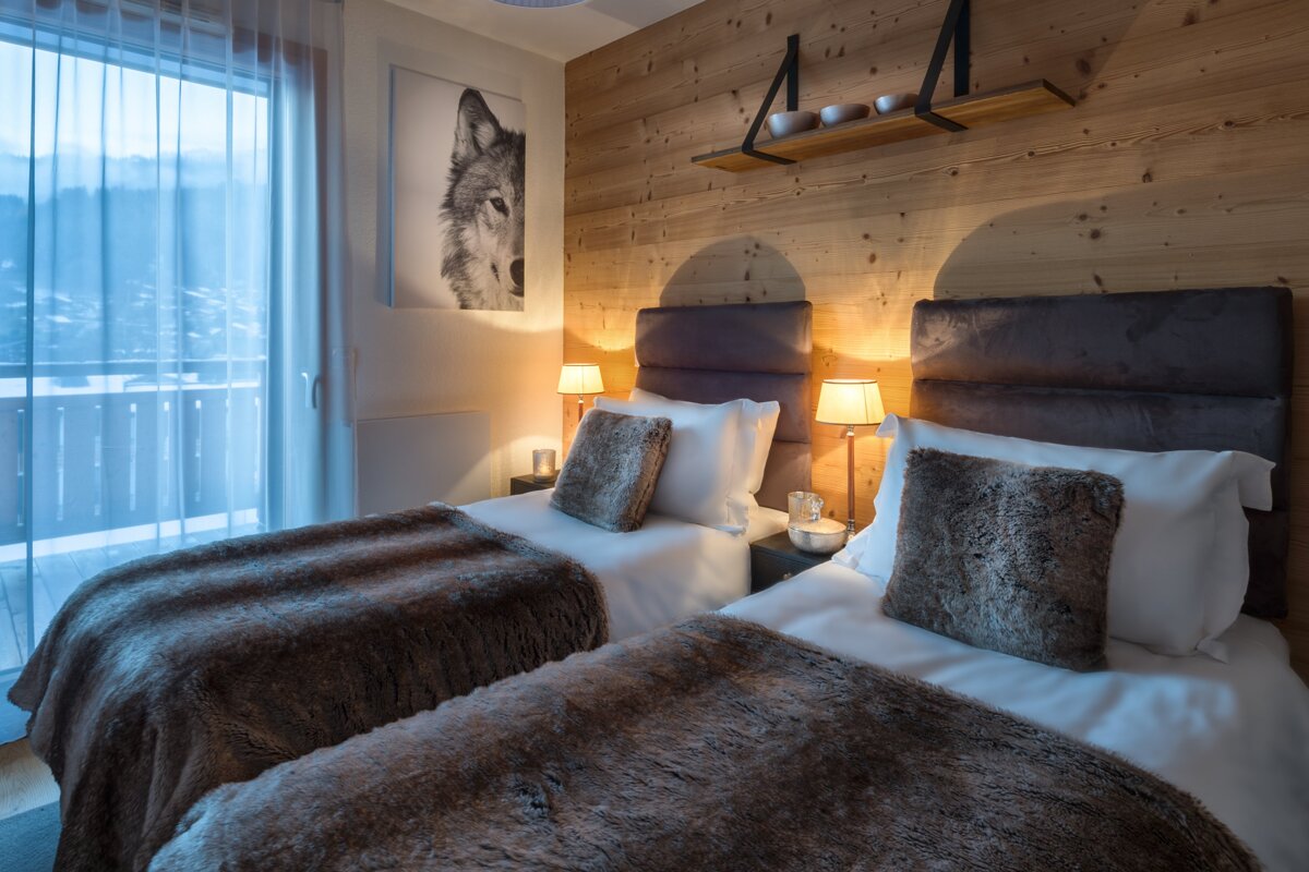 A bedroom with two beds and a picture of a wolf on the wall
