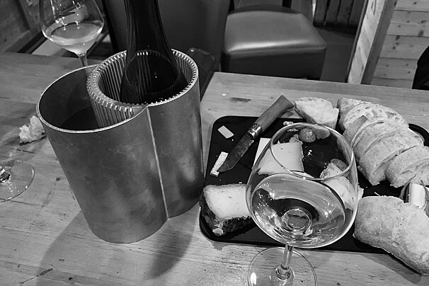 A bottle of wine sits next to a glass of wine