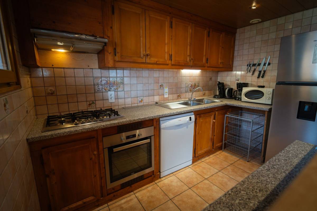 A kitchen with stainless steel appliances and wooden cabinets