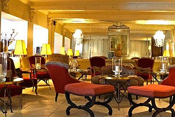 Bar with red and brown antique chairs and chanderliers