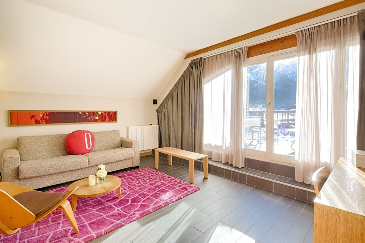 A living room with a couch and a pillow with the letter o on it