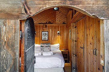 A wooden room with a bed and a picture on the wall that says