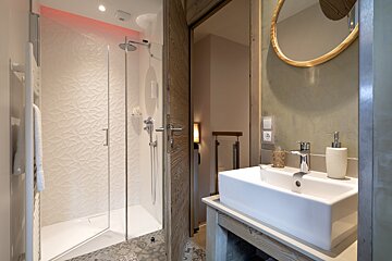 A bathroom with a sink and a walk in shower