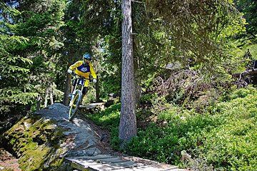 a mountain biker riding over a rock