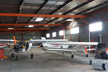 lots of small planes in a hangar