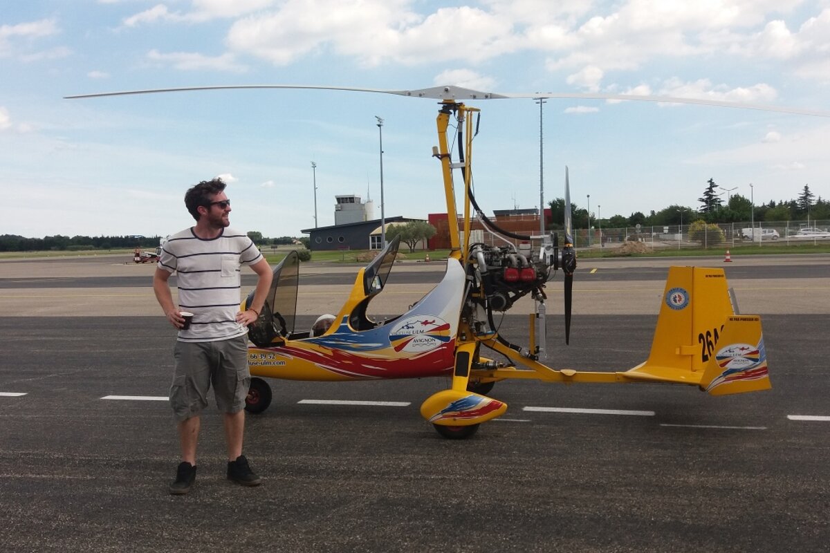 a man standing next to an open top helicopter