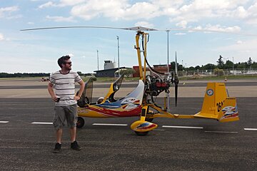 a man standing next to an open top helicopter