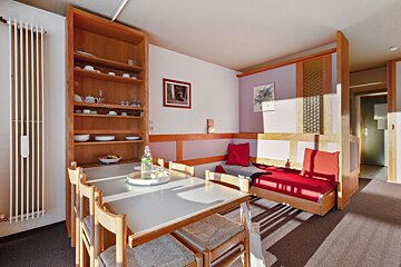 A living room with a table and chairs and a picture on the wall